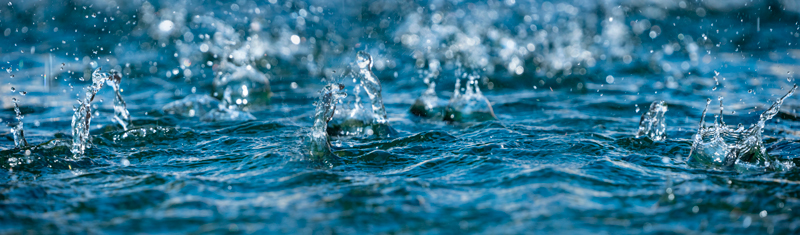 Gotas de agua salpicando sobre la superficie del mar, capturando el movimiento del agua en detalle
